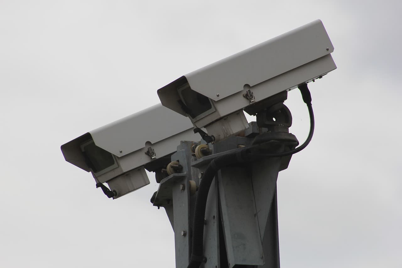 Two outdoor security cameras mounted on a pole.